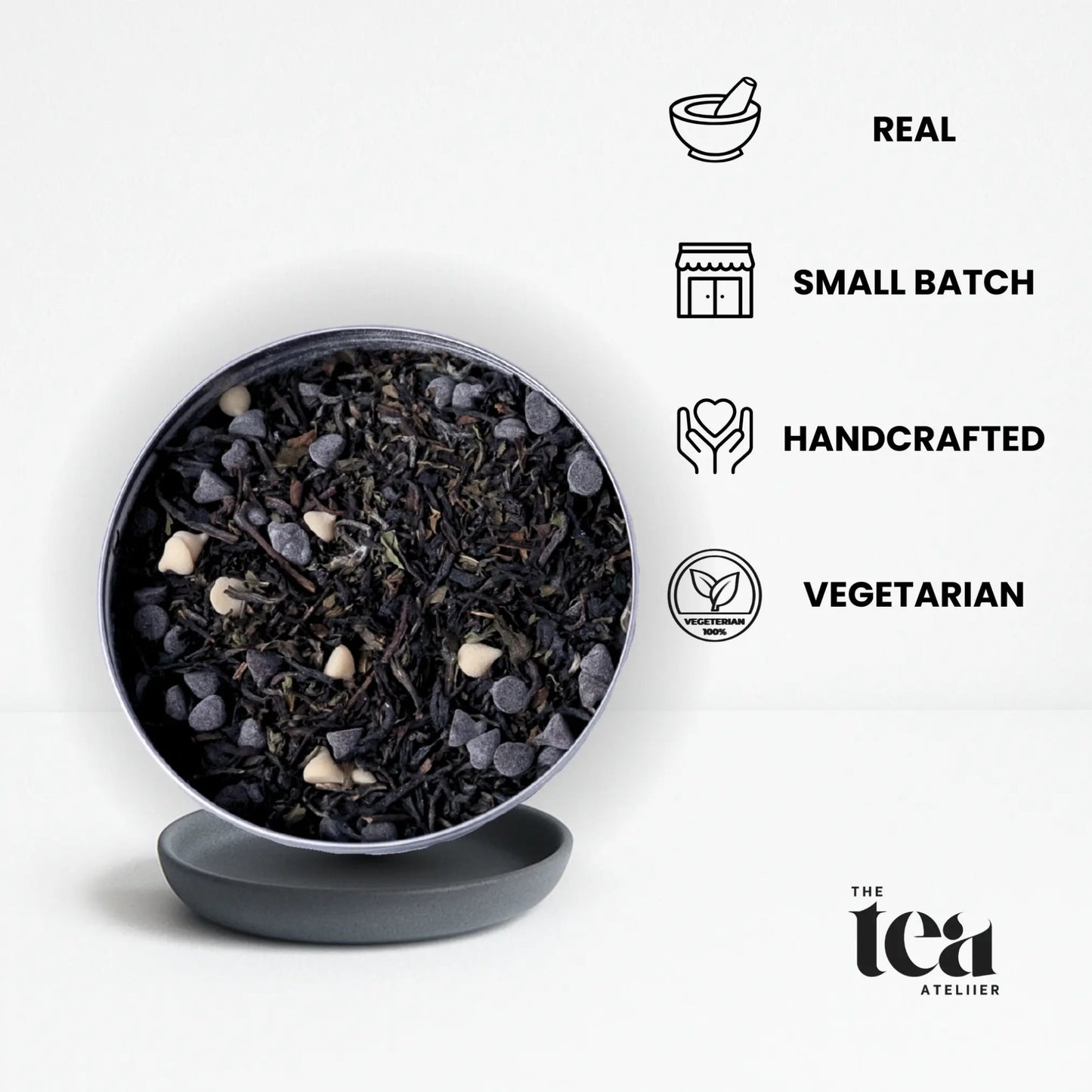 Tea leaves in a black bowl by The Tea Ateliier