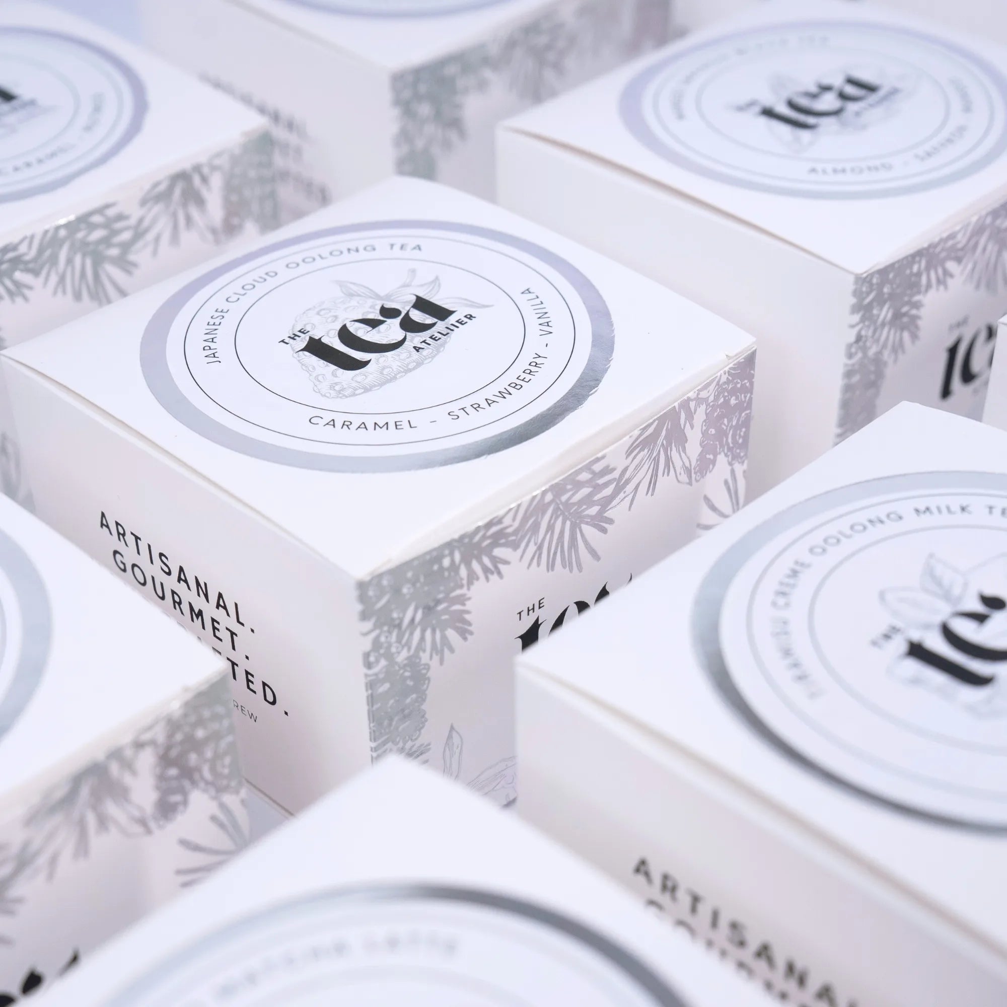 Close-up of tea boxes with 'The Tea Ateliier' branding.